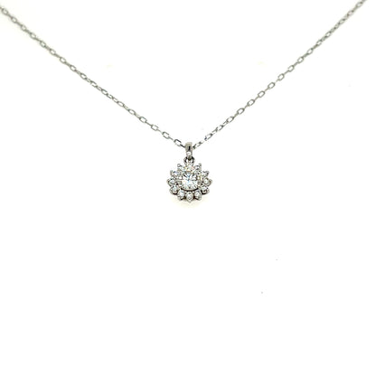A delicate silver chain necklace with a small flower-shaped pendant set with clear stones, displayed against a plain white background.