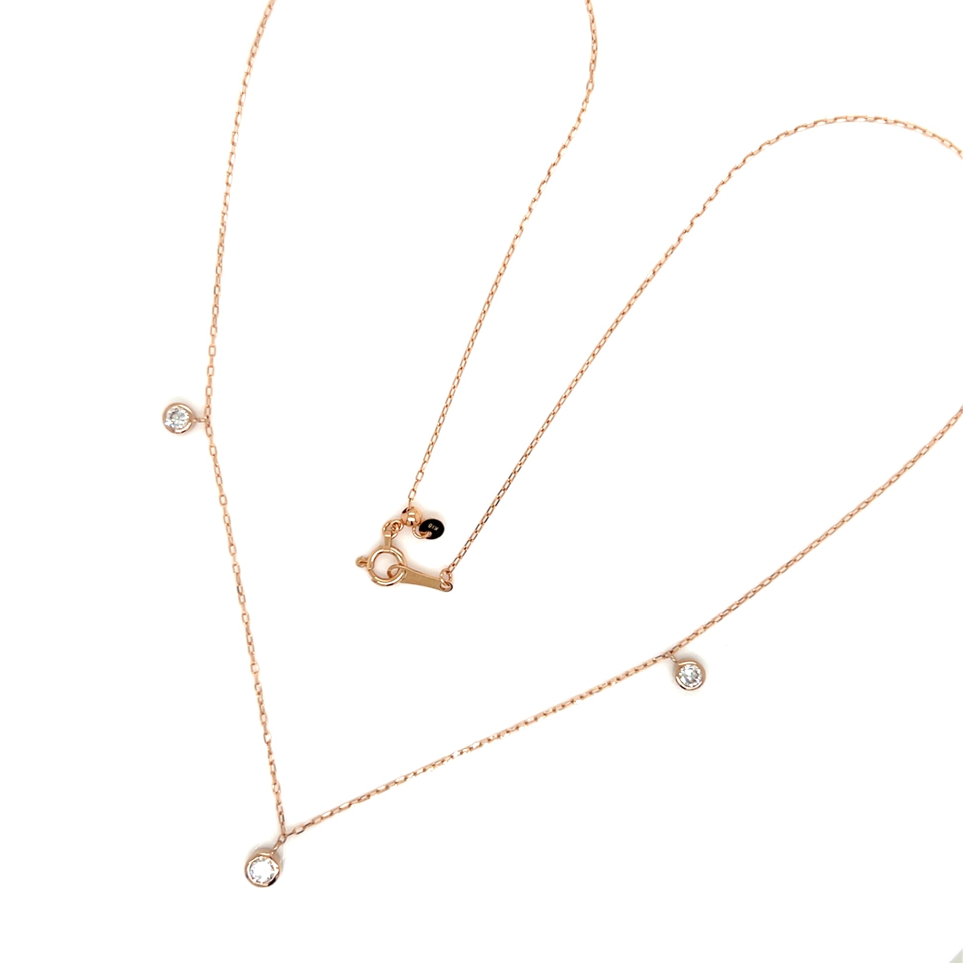 Rose gold necklace with heart pendant and small diamonds on a white background