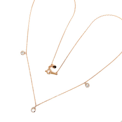 Rose gold necklace with heart pendant and small diamonds on a white background