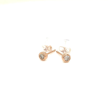 A pair of rose gold stud earrings with small clear gemstone clusters, shown on a plain white background.