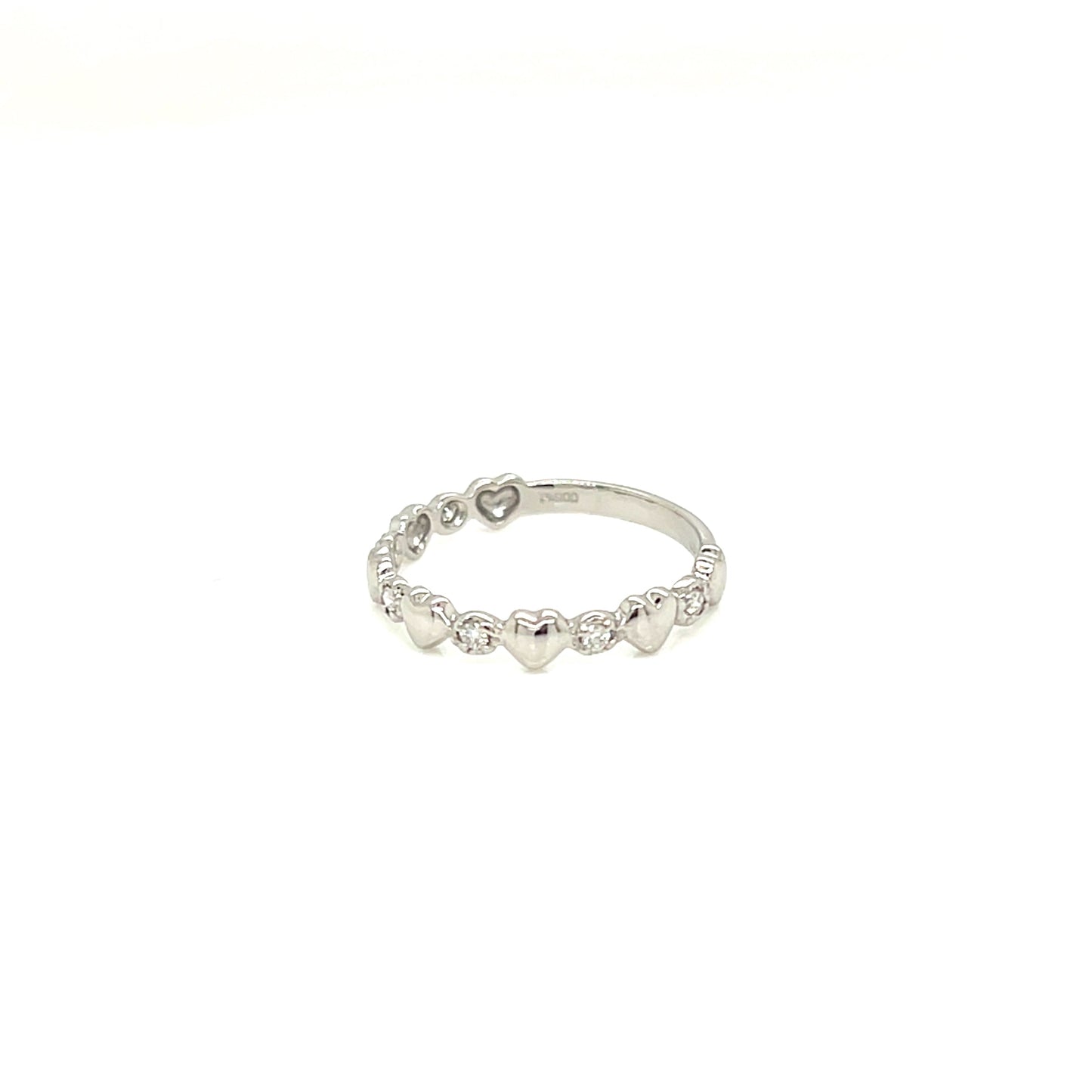 A delicate silver band ring featuring a row of small, evenly spaced heart charms, photographed against a solid white background.