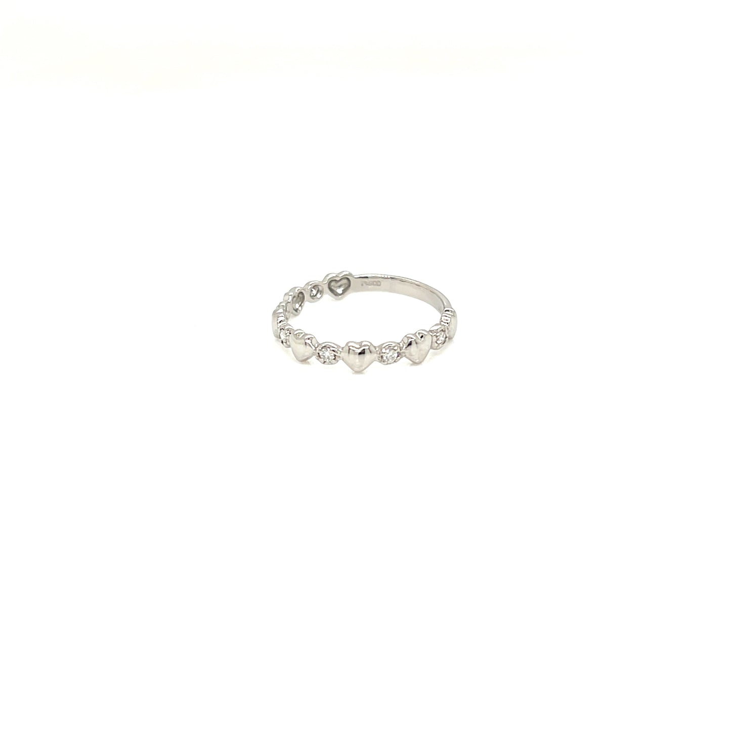 A delicate silver band ring featuring a row of small, evenly spaced heart-shaped clear stones, photographed against a solid white background.