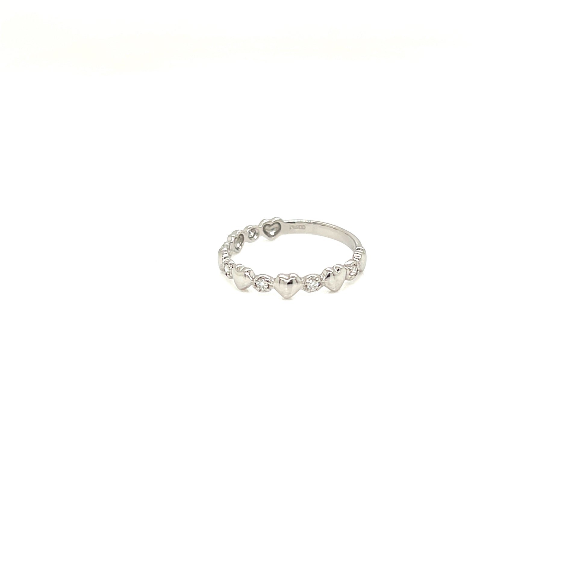 A delicate silver band ring featuring a row of small, evenly spaced heart-shaped clear stones, photographed against a solid white background.