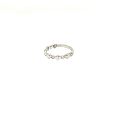 A delicate silver band ring featuring a row of small, evenly spaced heart-shaped clear stones, photographed against a solid white background.