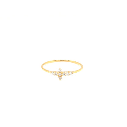 A delicate gold ring featuring a small star-shaped cluster of clear gemstones at the center, set against a plain white background.