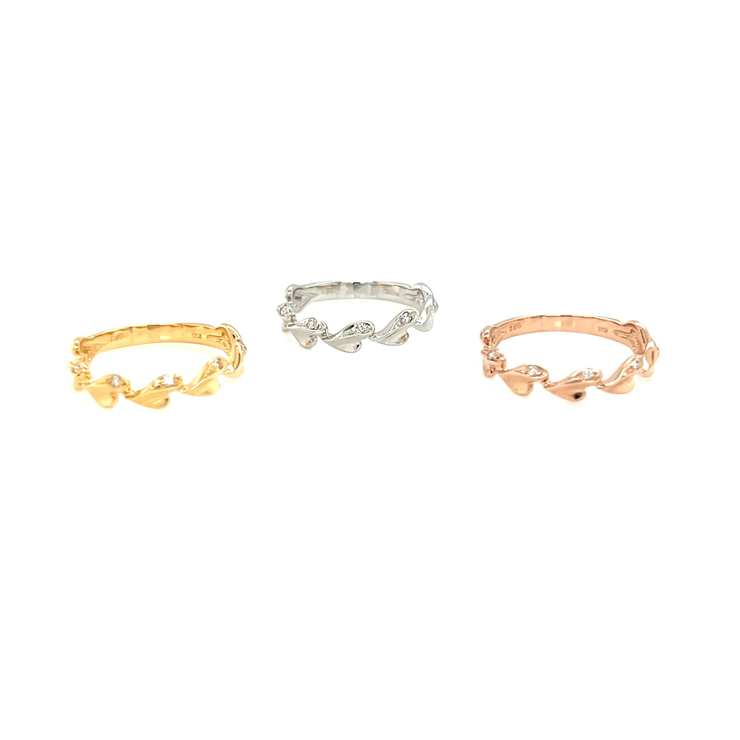 Three gold, silver, and rose gold rings on a white background