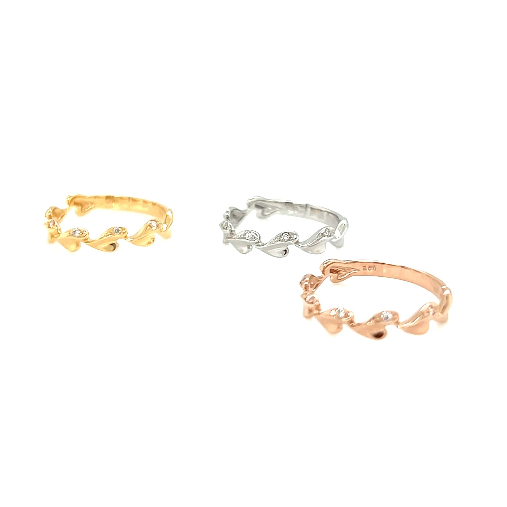 Three gold, silver, and rose gold rings on a white background