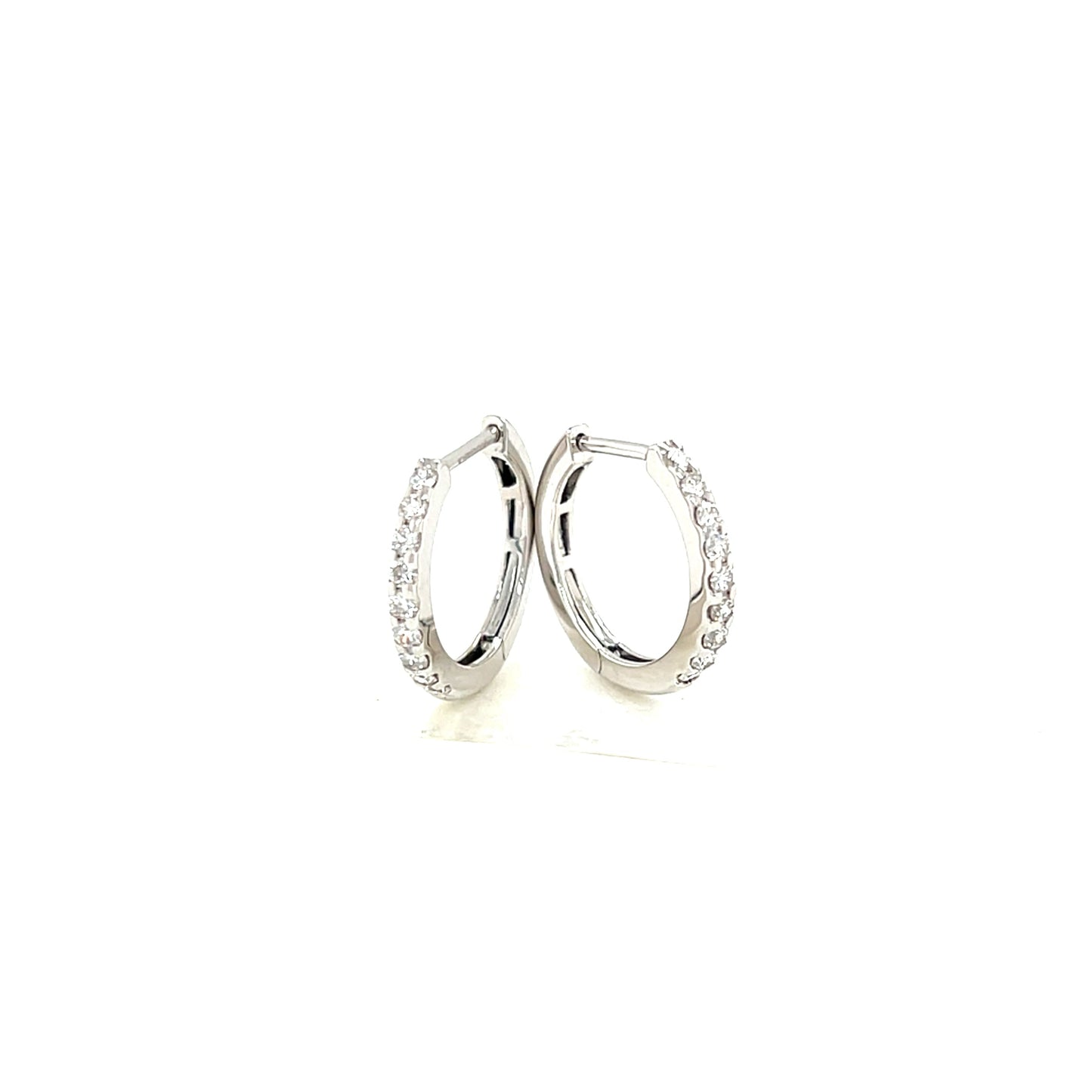 Pair of white gold hoop earrings on a white background