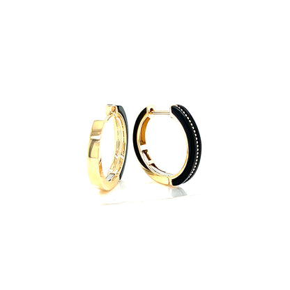 Pair of gold and black oynx hoop earrings on a white background