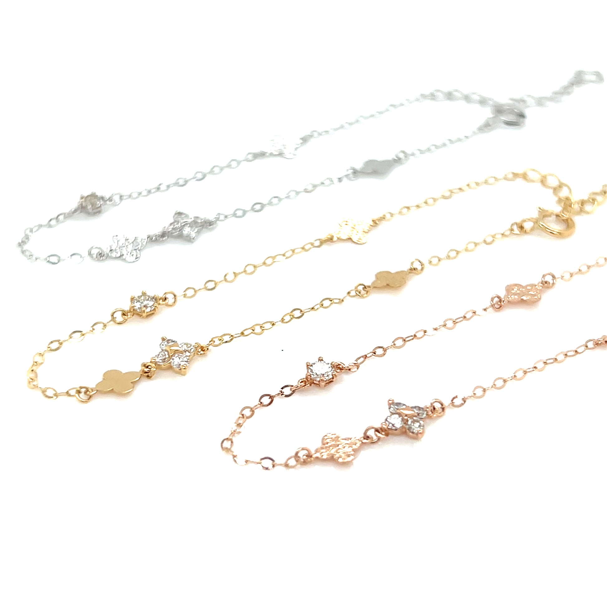 Clover pattern 18K gold bracelets of different colors on a white background