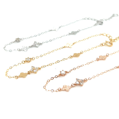 Clover pattern 18K gold bracelets of different colors on a white background