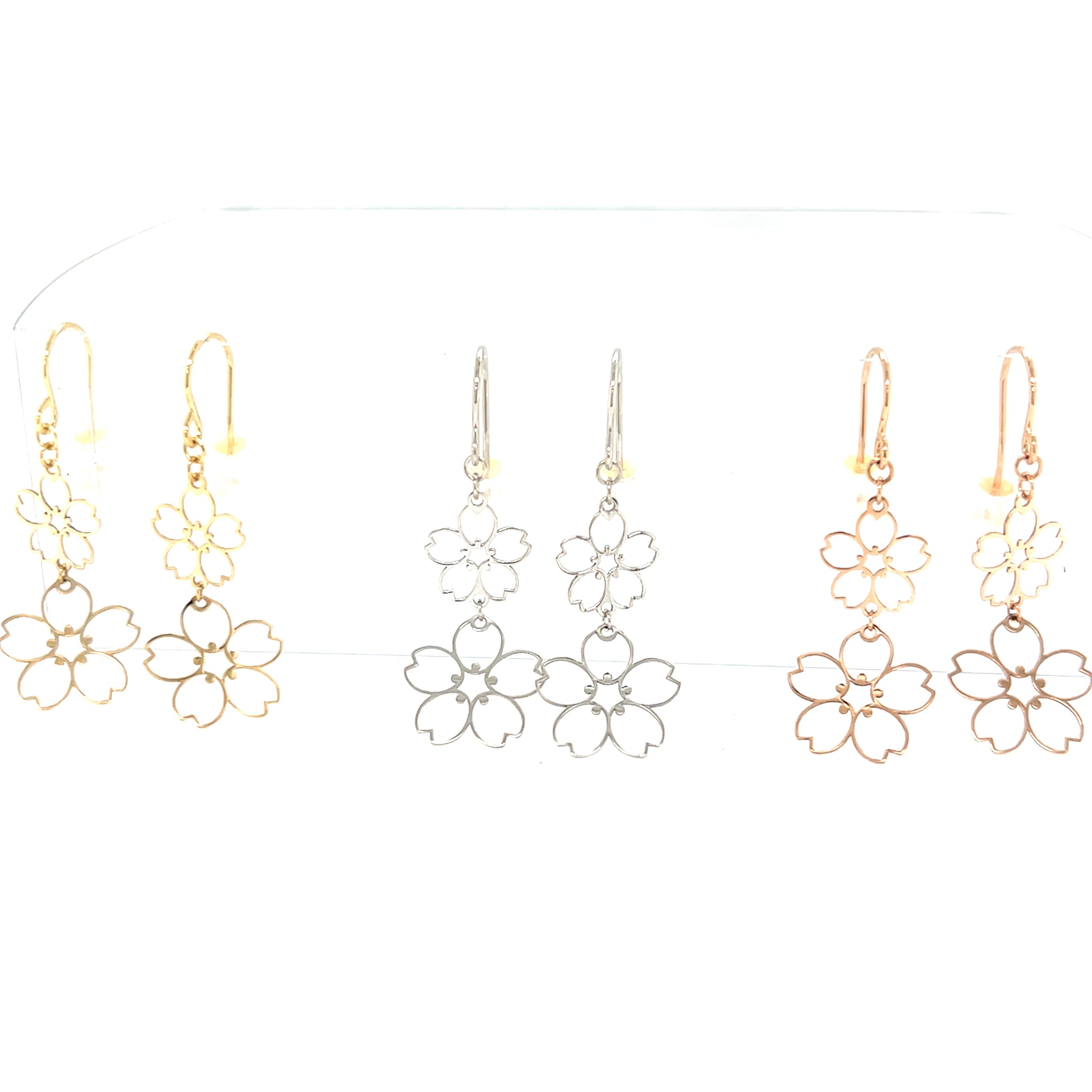 Hollow light Sakura floral drop earrings in 18k gold on a white background