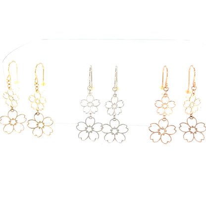 Hollow light Sakura floral drop earrings in 18k gold on a white background