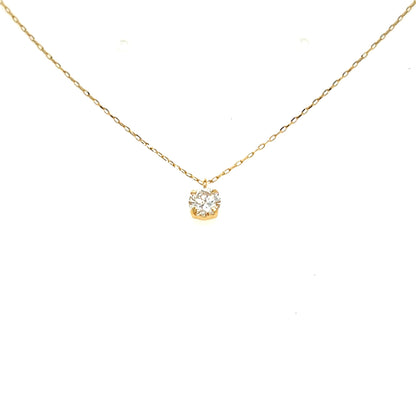 A delicate yellow gold chain necklace with a small, round bezel-set clear gemstone pendant, displayed against a solid white background.