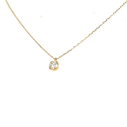 A delicate gold chain necklace with a small gold bezel-set pear-cut diamond pendant, shown against a plain white background.