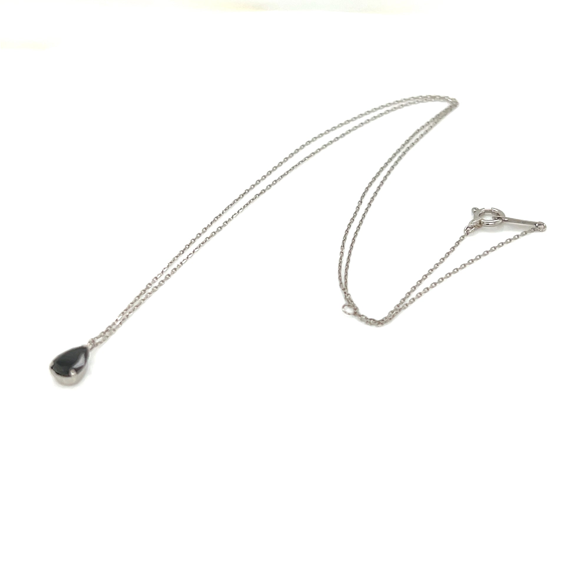 Necklace with a teardrop-shaped black diamond pendant on a white background