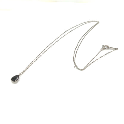 Necklace with a teardrop-shaped black diamond pendant on a white background